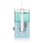 edel+white Flosserpik Pro Station - puissante douche buccale avec 10 niveaux de pression, 2 modes et 4 embouts pour un soin minutieux des dents et des gencives. Photo produit avec liquide dans le réservoir. 