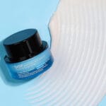 belif Moisturizing Eye Bomb 25ml – Augencreme mit Peptiden, Bakuchiol & Koffein gegen Falten & Augenringe. Imagebild white Creme Swirl on blue Background.