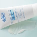 Dr. Belmeur Clarifying Facial Moisturizer 120ml - light moisturizer for acne-prone skin with niacinamide and panthenol. Image of product with cream in the background, close-up. 